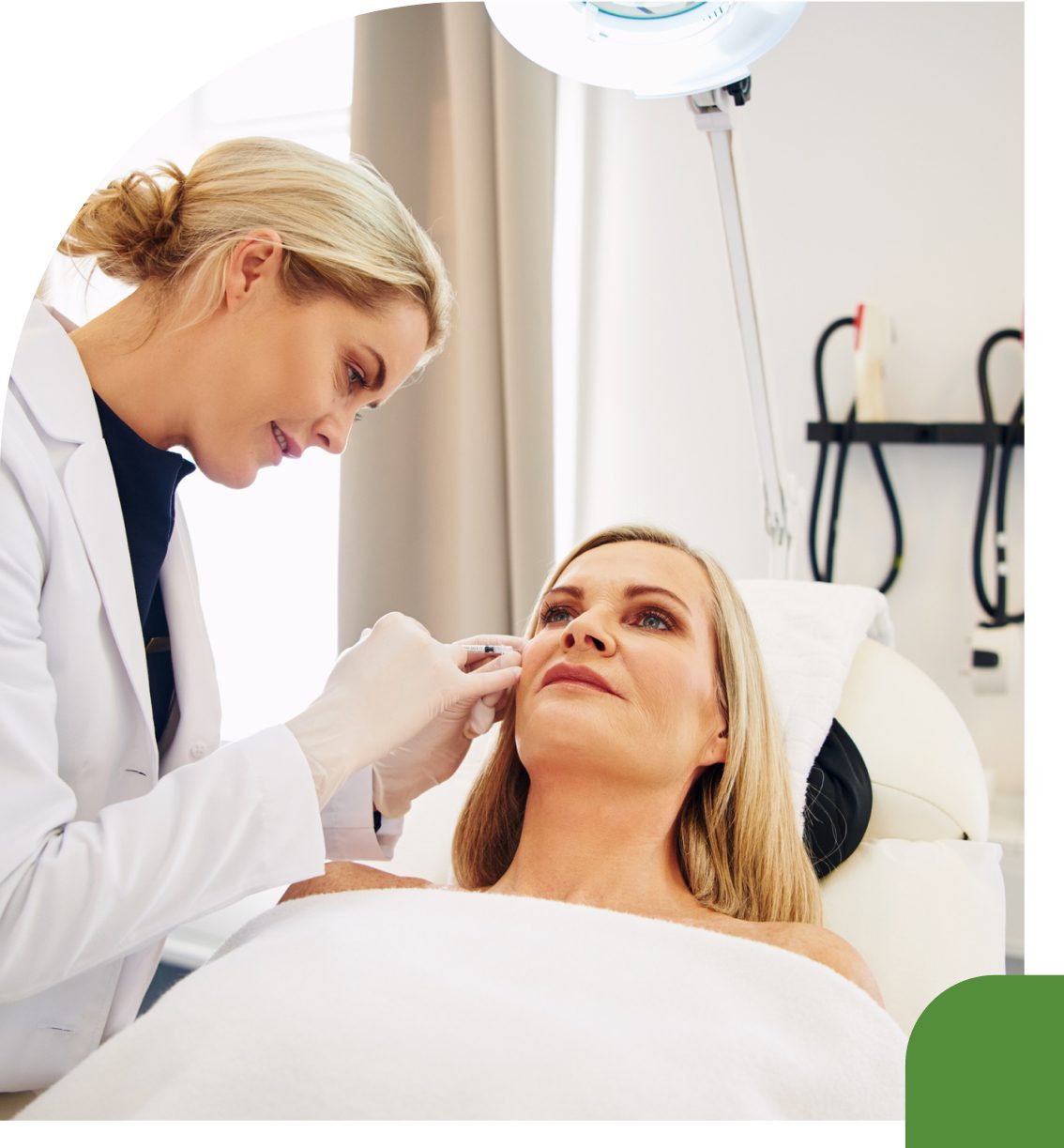 A dermatologist examines a woman's face in a clinic.
