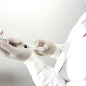 A healthcare professional holding a syringe and vial.