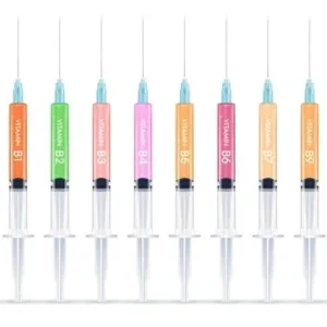 Eight syringes with colorful liquid inside arranged in a row.