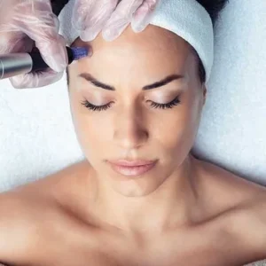 A woman receiving a facial treatment with a handheld device.