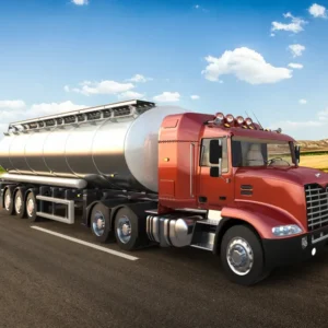 A red tanker truck driving on a highway under a blue sky.
