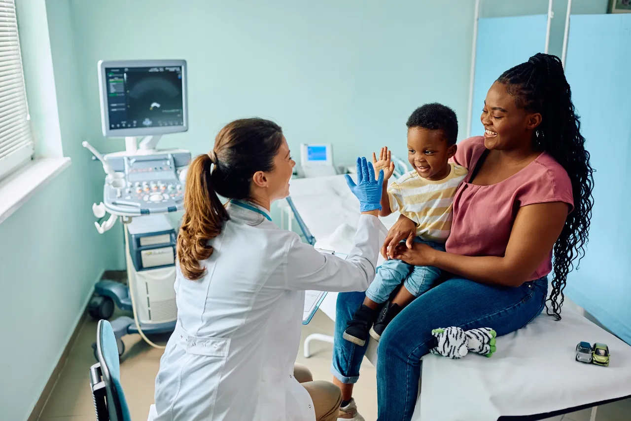 Doctor examining a child held by his mother in a clinic.