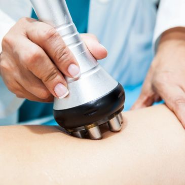 A therapist using a handheld device on a patient's back.