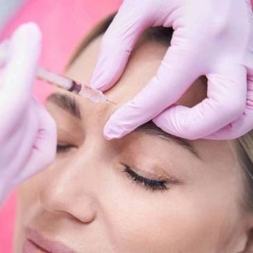 A woman receiving eyebrow tattooing treatment.