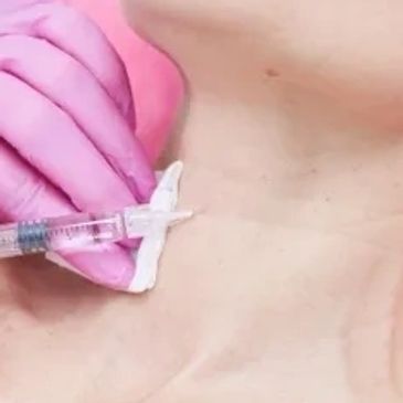 A syringe injecting into the neck area with a gloved hand.