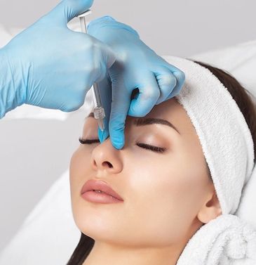 A woman receiving a facial treatment with gloves on.