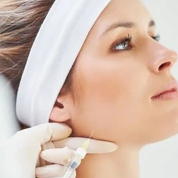 Woman receiving a cosmetic injection in the jaw area.