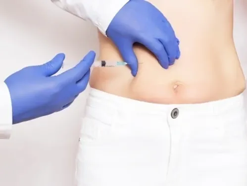 A person receiving an injection in the abdominal area.