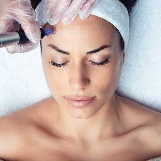 Woman receiving a facial treatment with a beauty device.