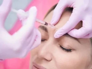 A woman receiving a cosmetic injection on her forehead.